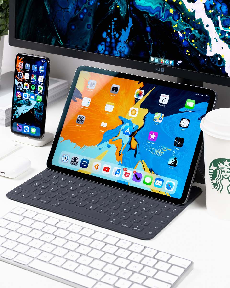 mobile phone black iPad near the white keyboard cell phone